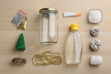 Photo of Items for handmade snow globe on wooden table, flat lay