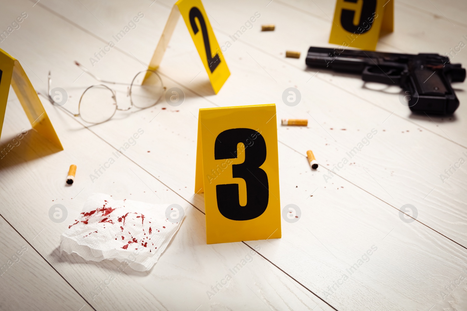 Photo of Evidences and crime scene marker on white wooden table