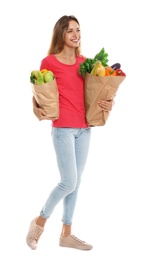 Photo of Young woman with bags of fresh vegetables isolated on white