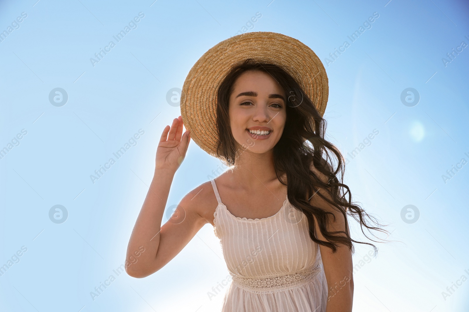 Photo of Happy young woman with beach hat against blue sky on sunny day