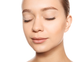 Portrait of young woman with foundation on her face against white background