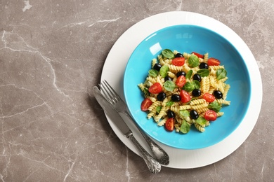 Plate with delicious pasta primavera on grey background, top view