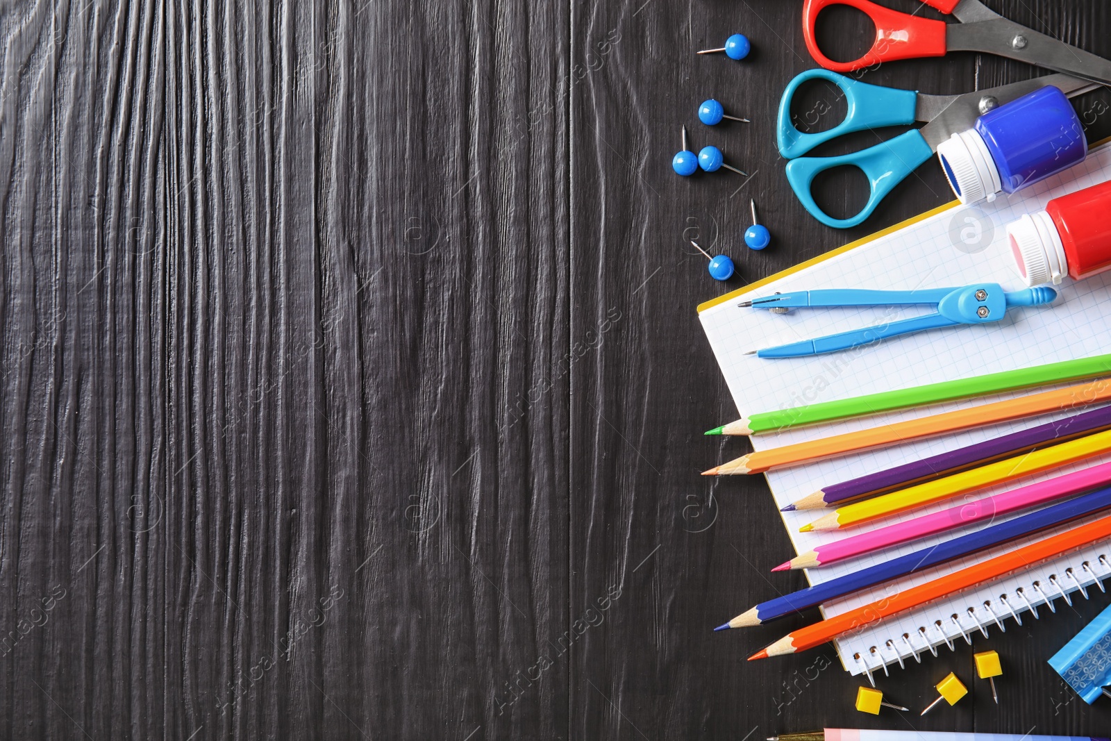 Photo of Different school stationery with space for design on wooden background, flat lay