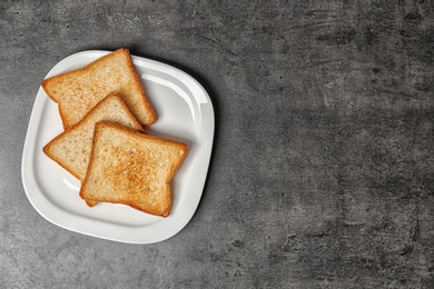 Photo of Plate with toasted bread on grey background, top view