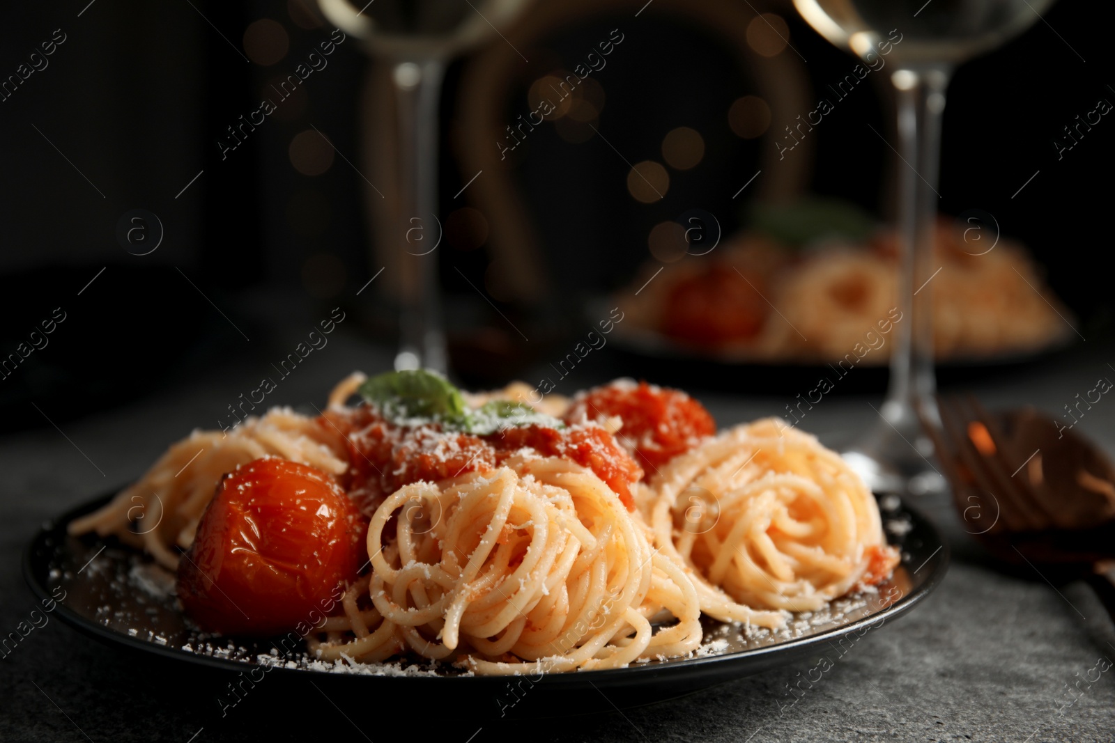 Photo of Tasty pasta with basil, tomatoes and cheese on grey table. Closeup