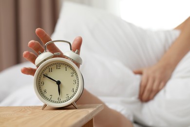 Photo of Woman turning off alarm clock in bedroom, closeup. Space for text