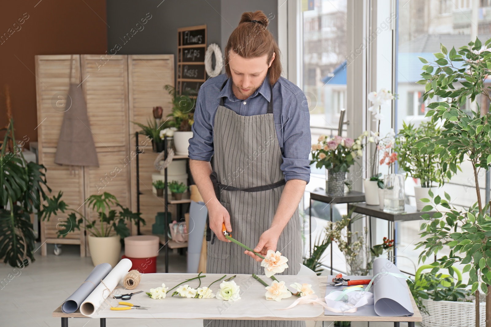 Photo of Male florist creating bouquet at workplace