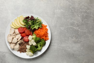 Balanced diet and healthy foods. Plate with different delicious products on grey table, top view. Space for text