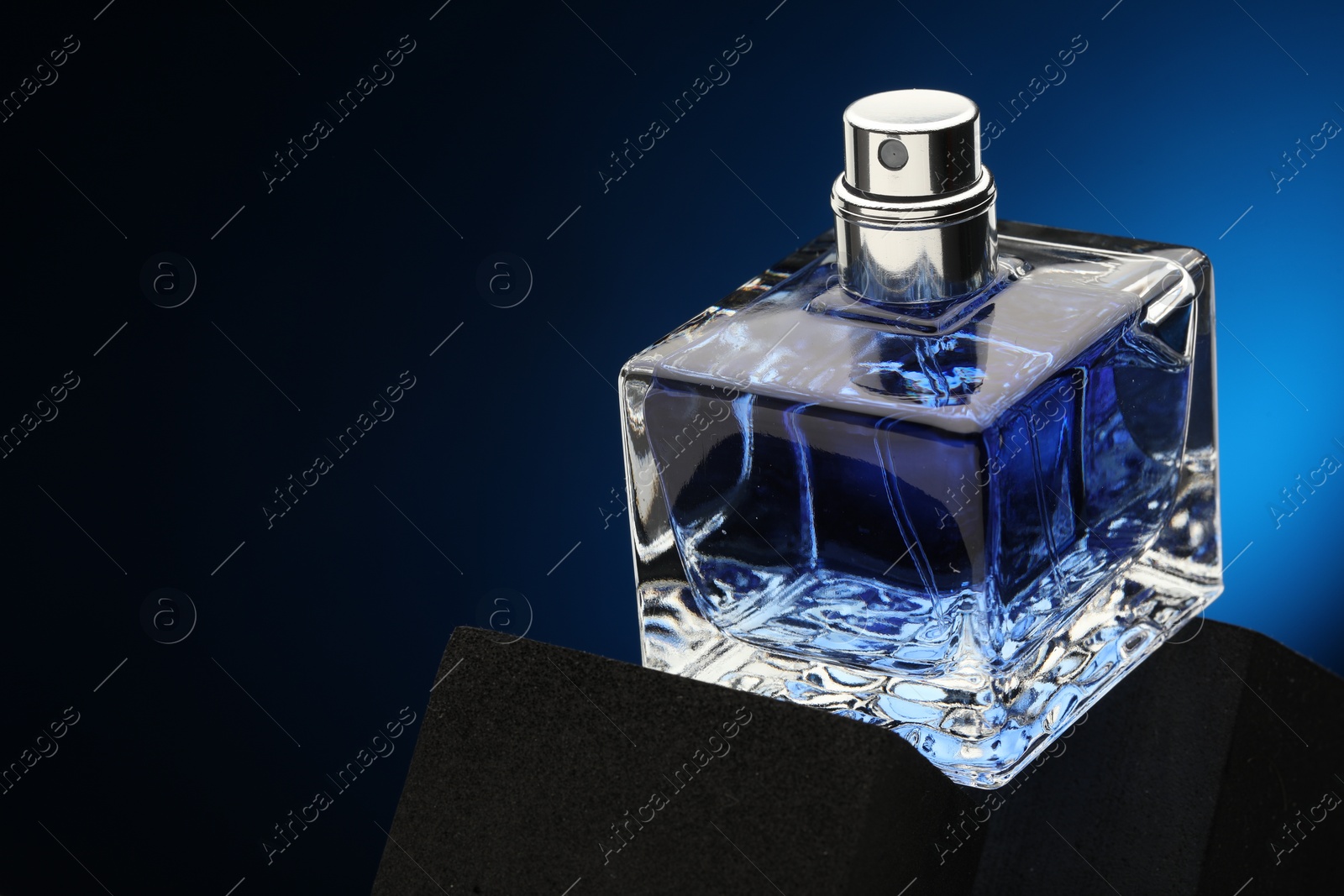 Photo of Luxury men`s perfume in bottle against dark background, space for text