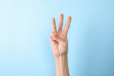 Photo of Woman showing number six on color background, closeup. Sign language