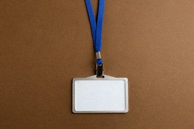Photo of Blank badge on brown background, top view. Mockup for design