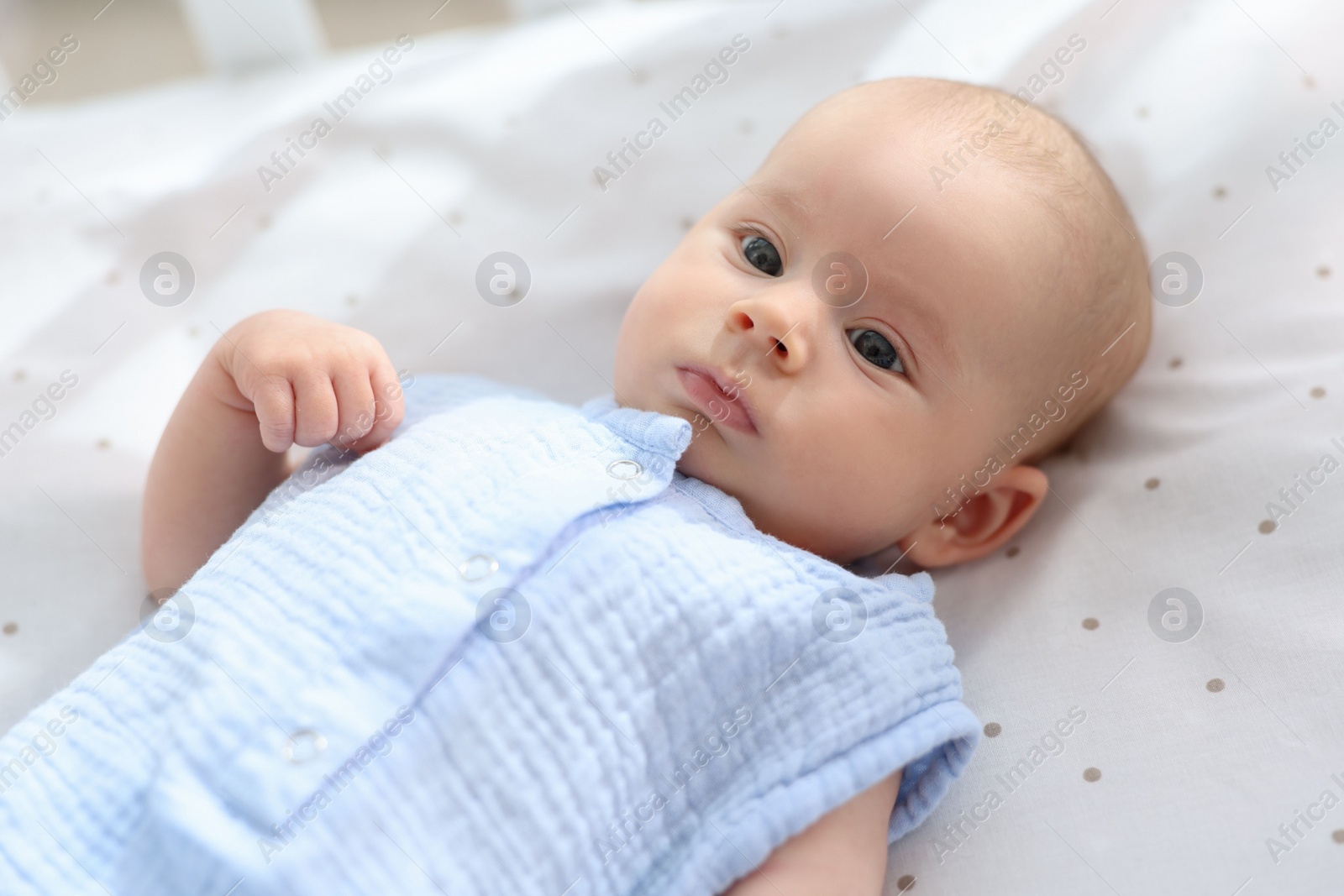 Photo of Cute little baby lying in crib at home