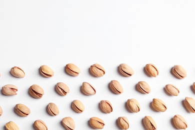 Photo of Organic pistachio nuts on white background, flat lay. Space for text