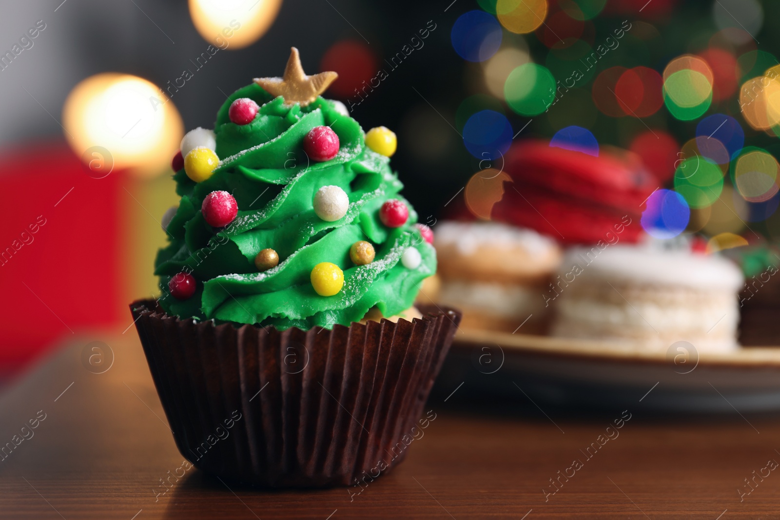 Photo of Christmas tree shaped cupcake on wooden table indoors, closeup. Space for text