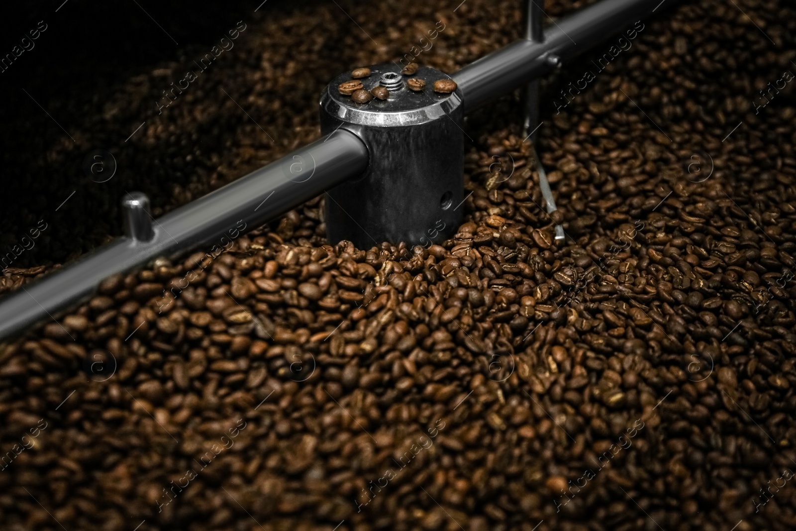 Photo of Modern coffee roaster machine with beans, closeup