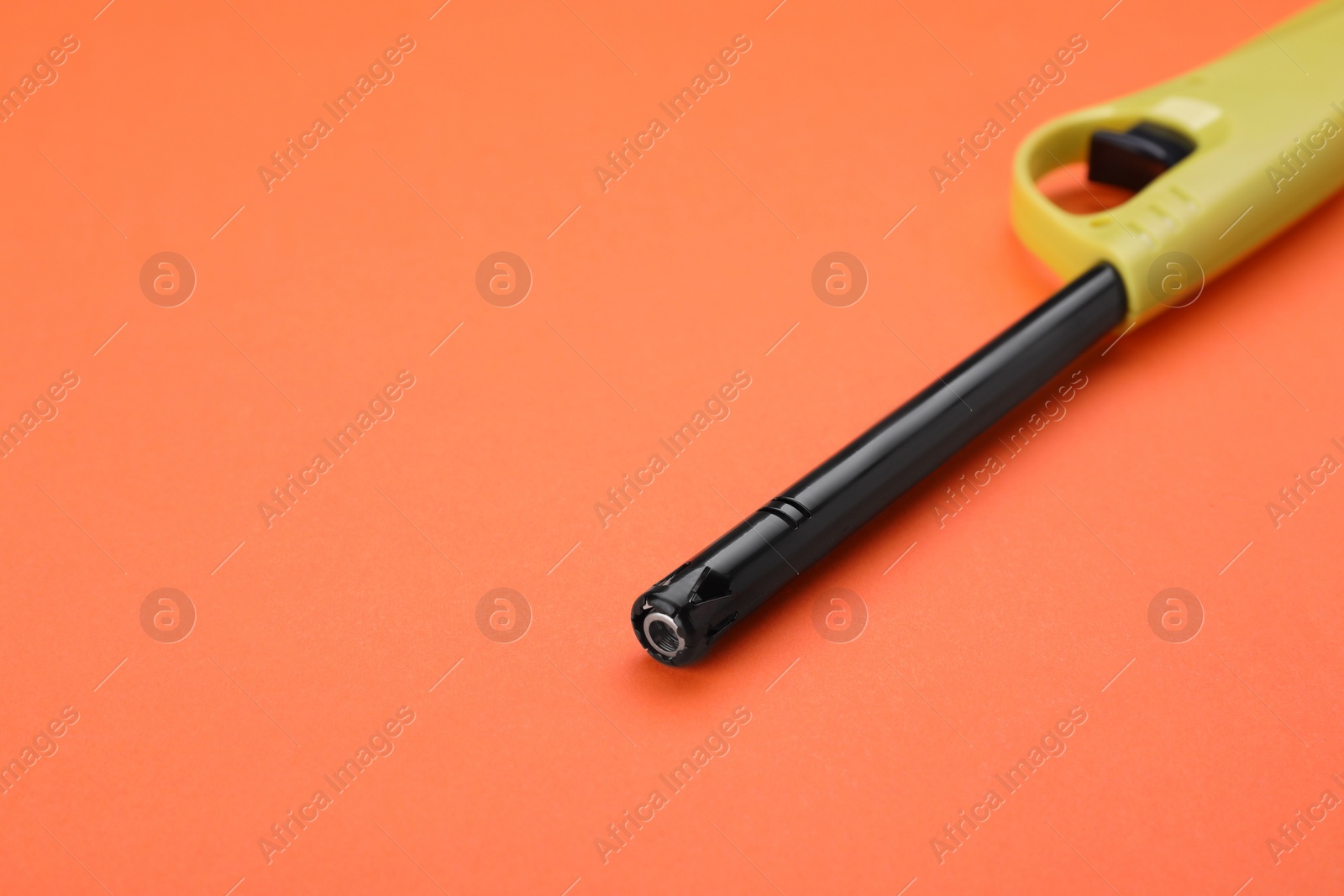 Photo of One gas lighter on orange background, closeup. Space for text