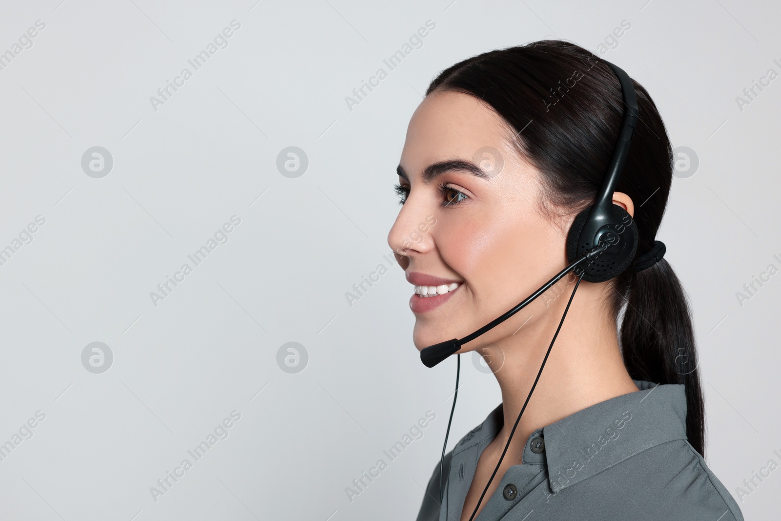 Photo of Hotline operator with modern headset on light grey background, space for text. Customer support