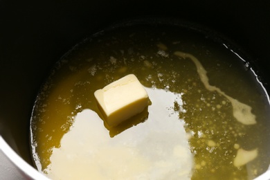 Pot with tasty melting butter, closeup view