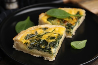 Photo of Pieces of delicious pie with spinach on table, closeup