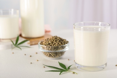 Photo of Composition with glass of hemp milk on white table indoors