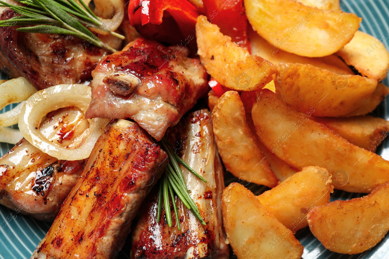 Photo of Delicious grilled ribs and garnish, closeup view