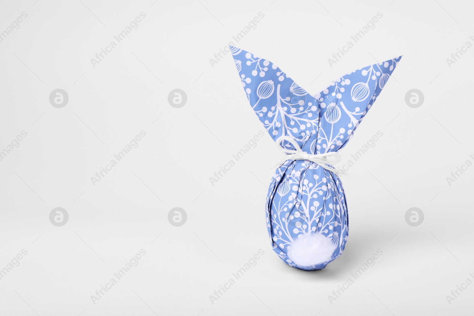 Photo of Easter bunny made of wrapping paper and egg on white background. Space for text