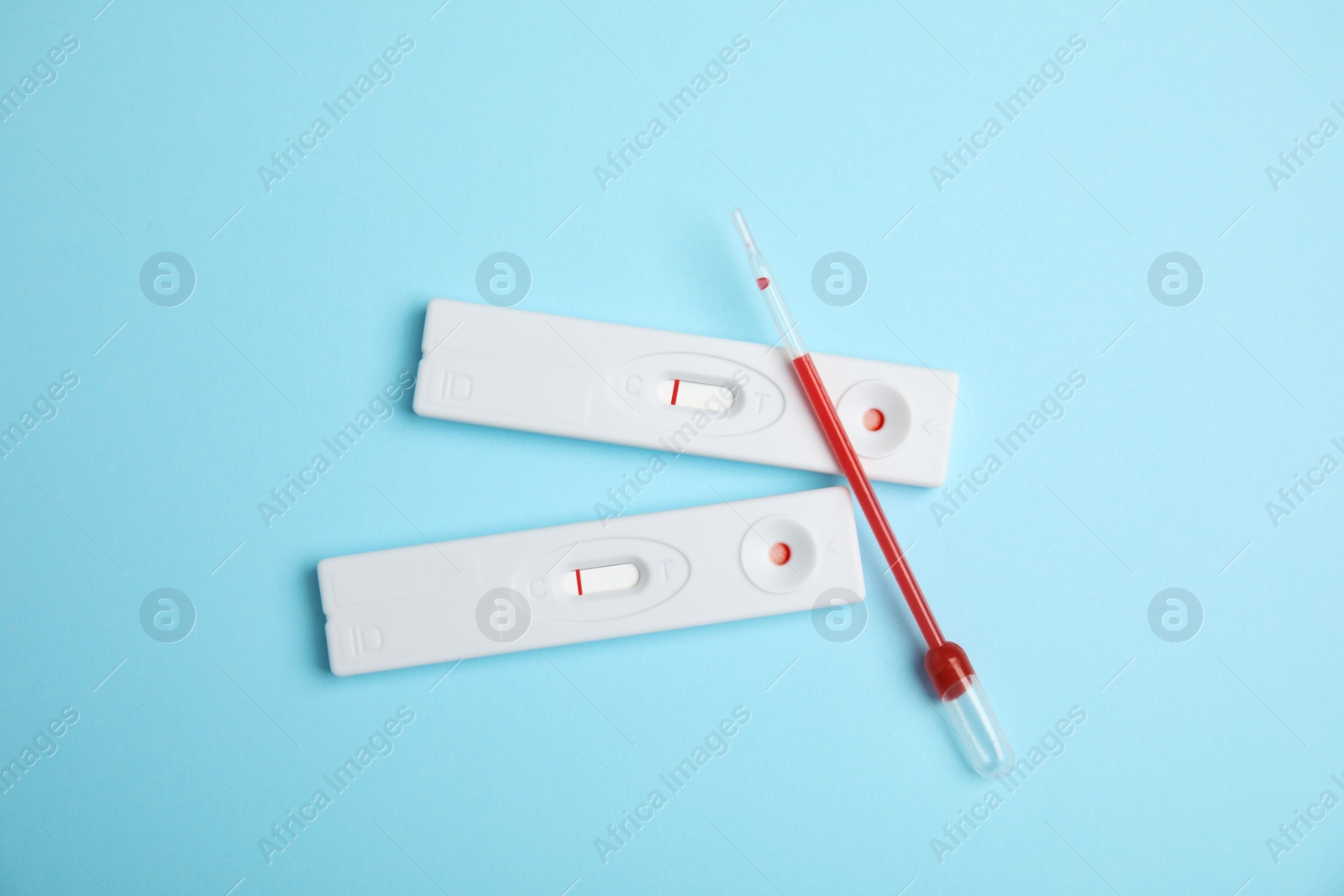 Photo of Disposable express hepatitis test kit on light blue background, flat lay