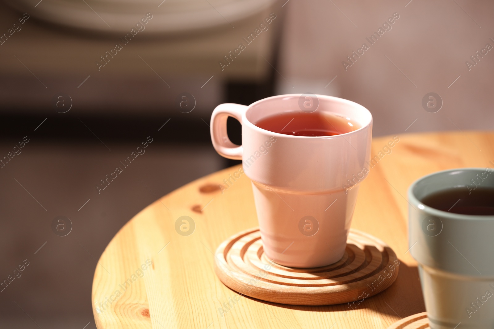 Photo of Aromatic tea in cup on wooden table, space for text