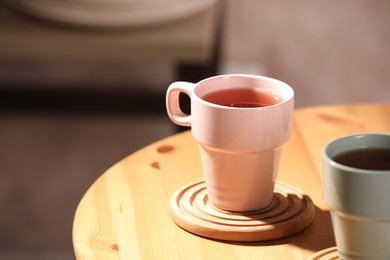 Photo of Aromatic tea in cup on wooden table, space for text