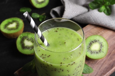 Photo of Delicious kiwi smoothie on wooden board, closeup