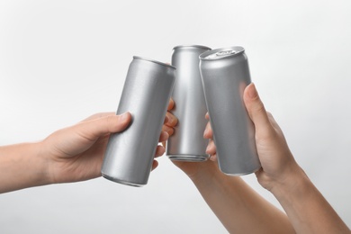 Photo of People holding aluminum cans on white background, closeup. Space for design