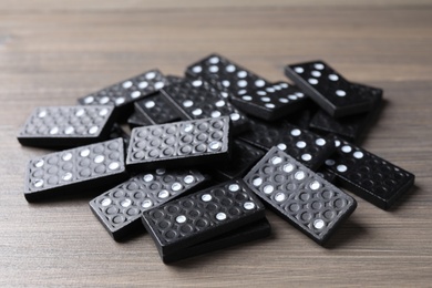 Photo of Pile of black domino tiles on wooden table