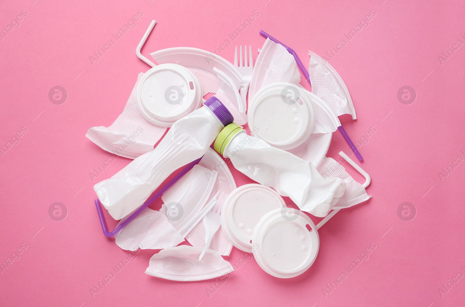 Photo of Pile of different plastic items on pink background, flat lay