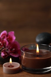 Photo of Beautiful spa composition with burning candles and flowers on wooden table