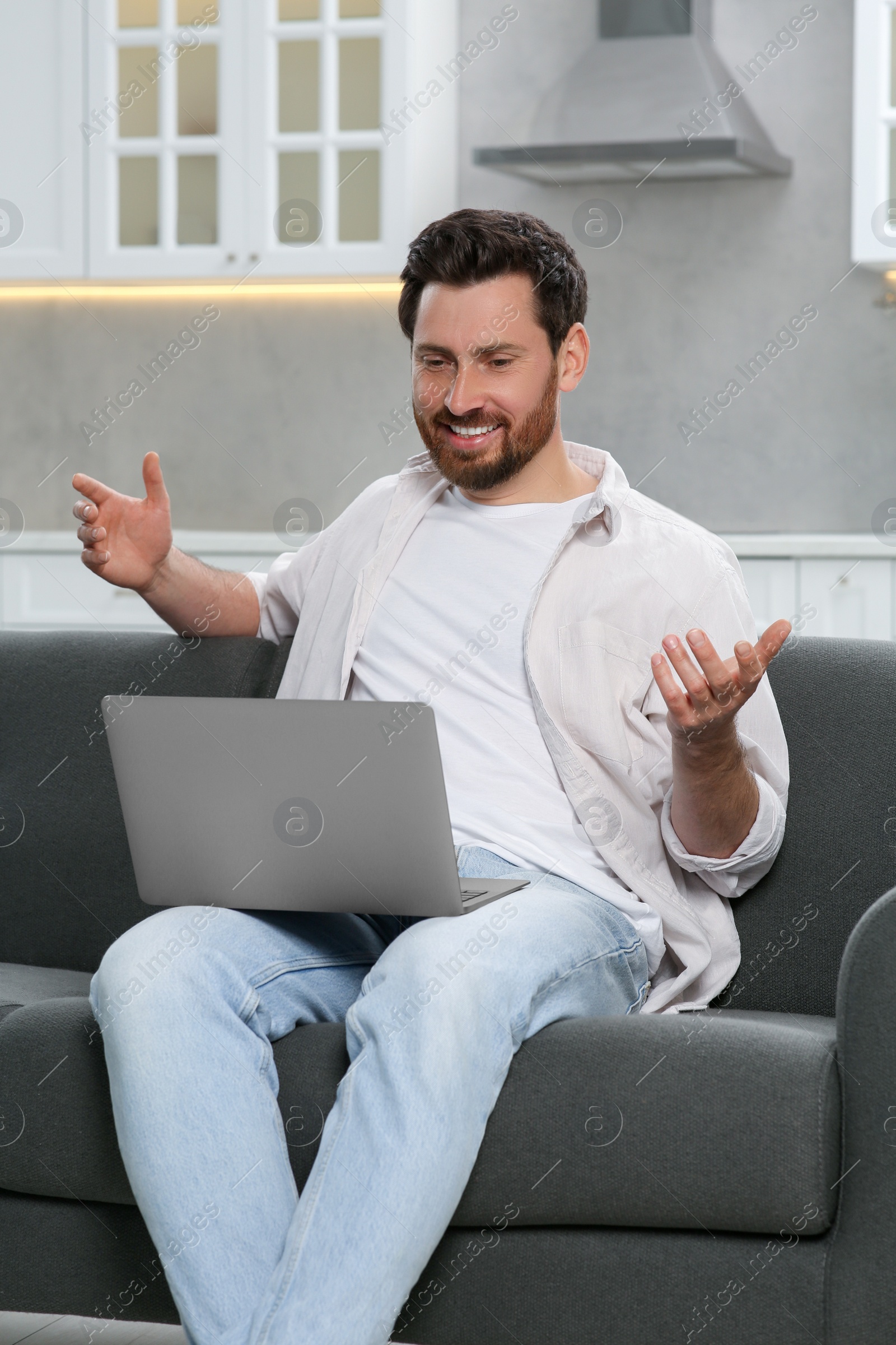 Photo of Man having video chat via laptop at home