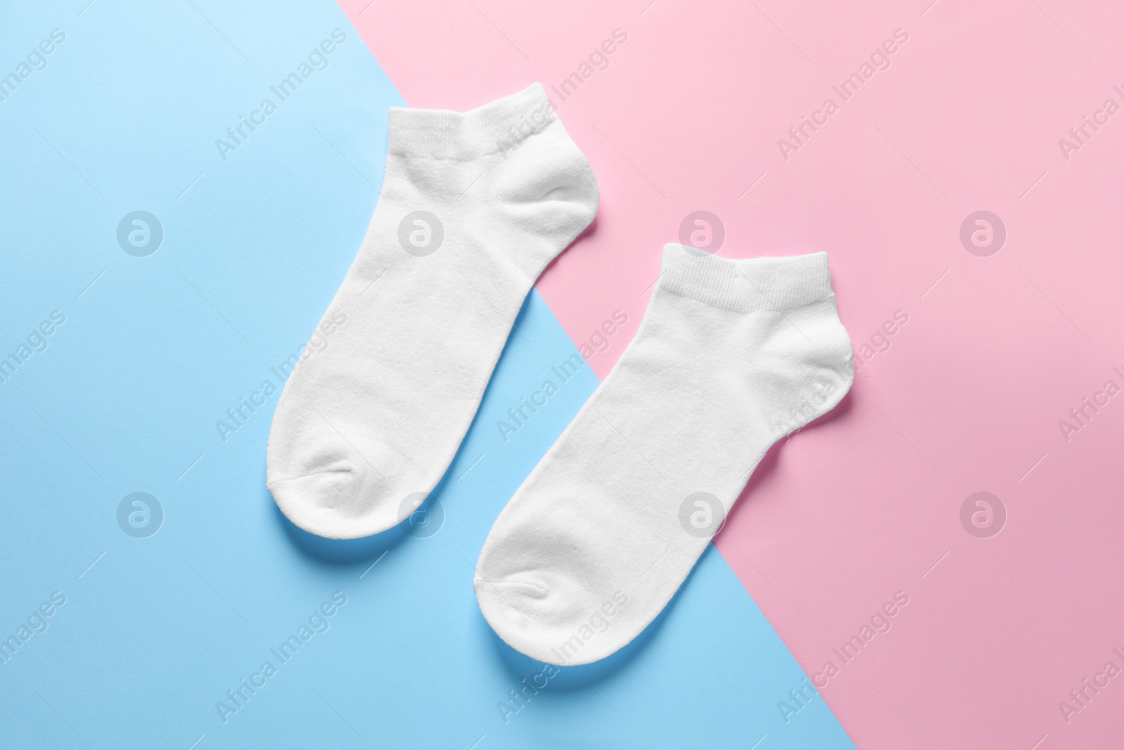 Photo of Pair of white socks on colorful background, flat lay