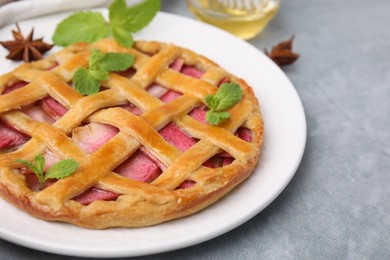 Delicious apple pie with mint on grey table, closeup