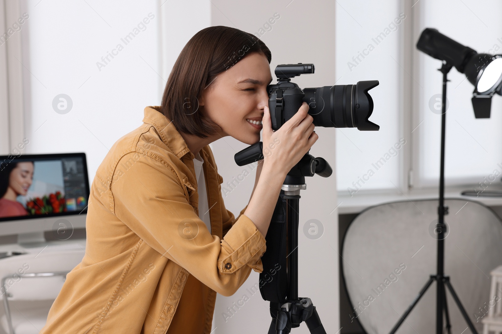 Photo of Professional photographer taking picture in modern photo studio