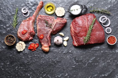 Photo of Fresh raw beef cuts and different spices on grey textured table, flat lay. Space for text