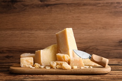 Parmesan cheese with board and knife on wooden table