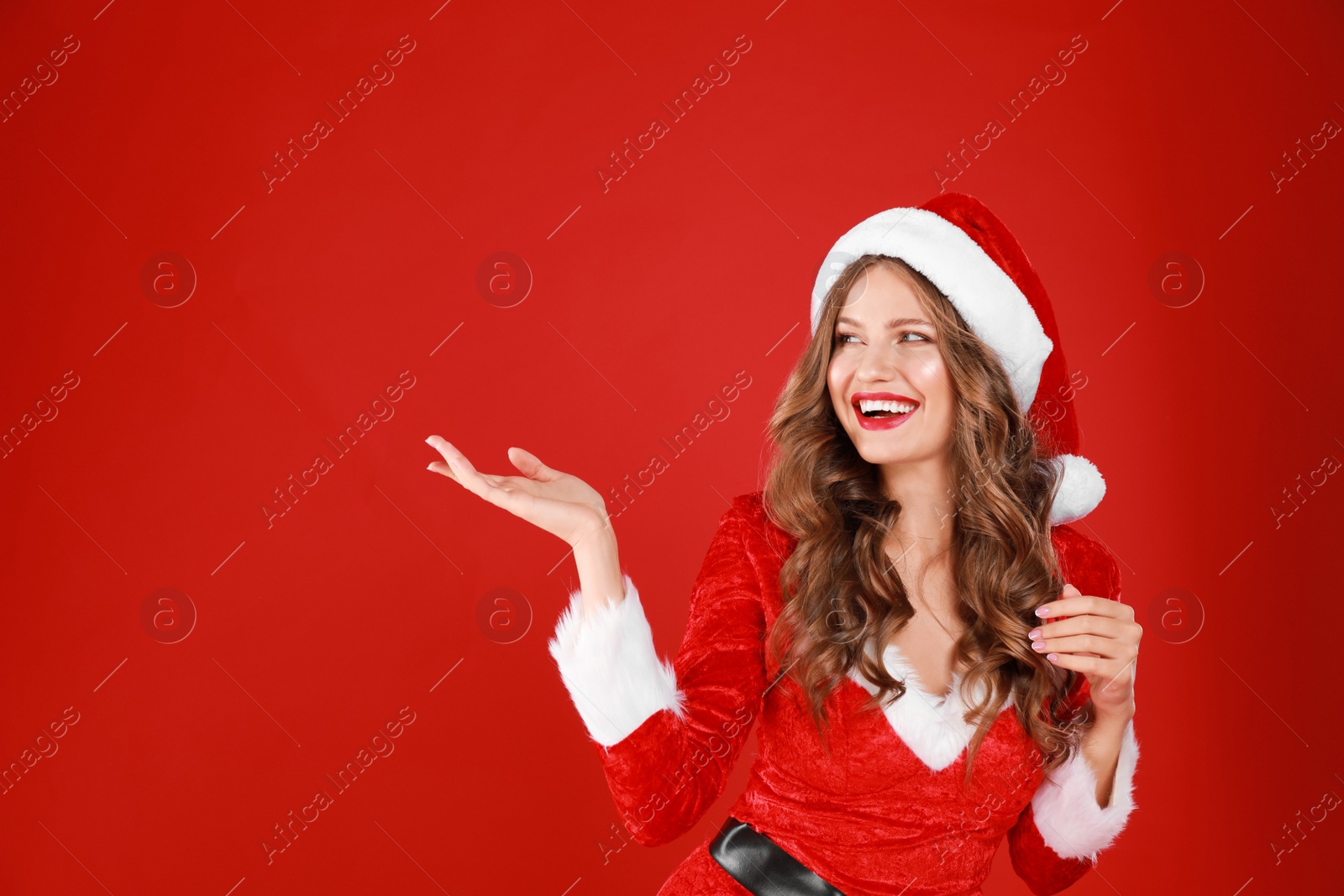 Photo of Beautiful Santa girl on red background. Christmas celebration