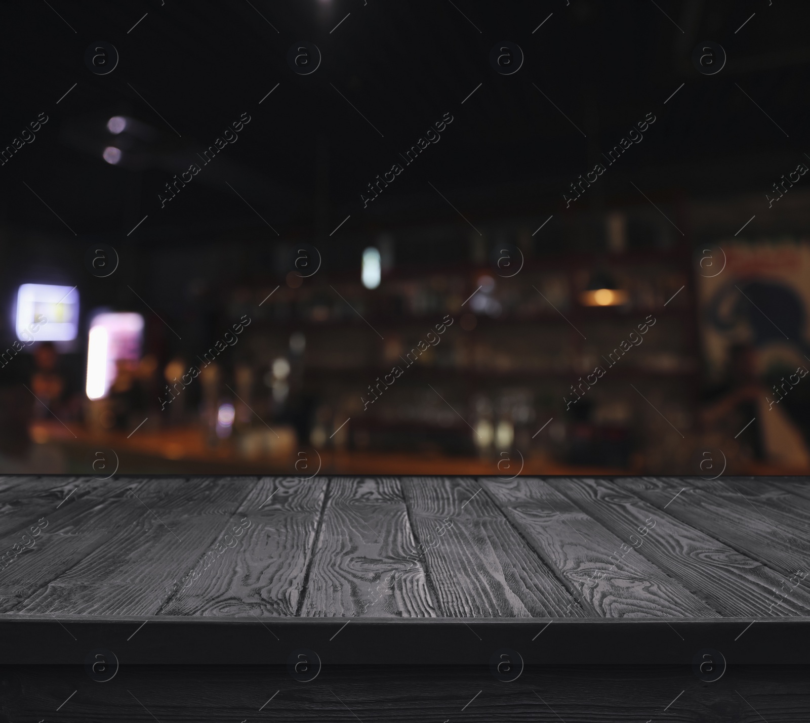 Image of Empty black wooden surface and blurred view of bar interior. Space for design