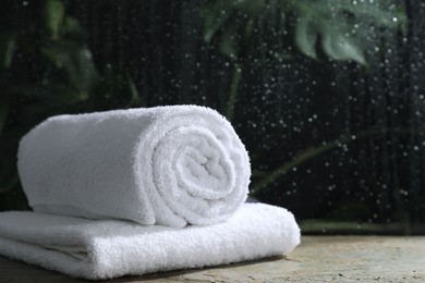 White terry towels on table in bathroom, space for text