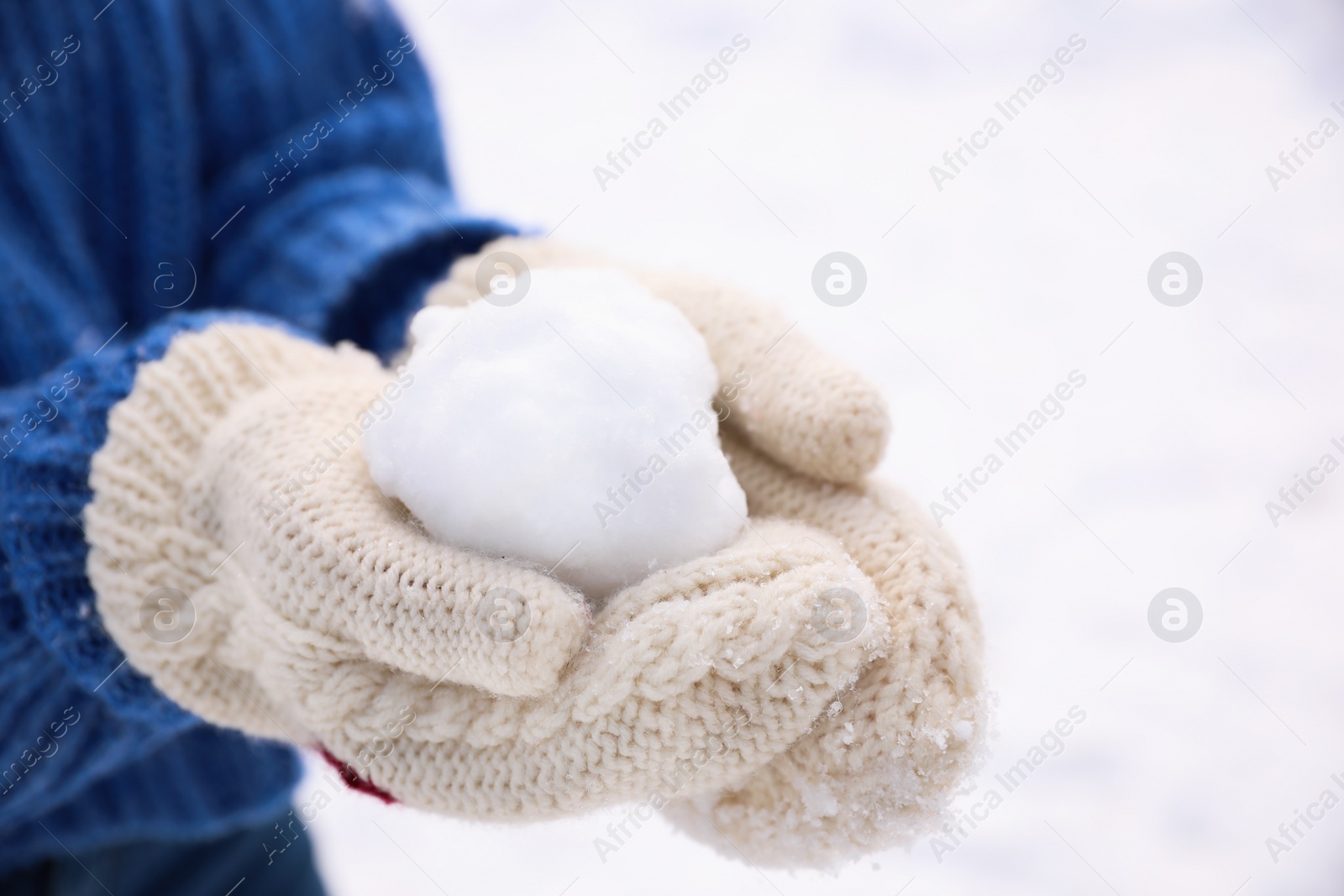 Photo of Woman with snowball outdoors, closeup. Winter vacation