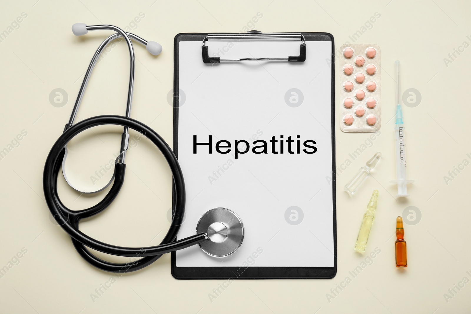 Photo of Clipboard with word Hepatitis and medical supplies on beige background, flat lay