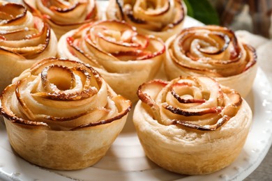 Freshly baked apple roses on plate, closeup. Beautiful dessert