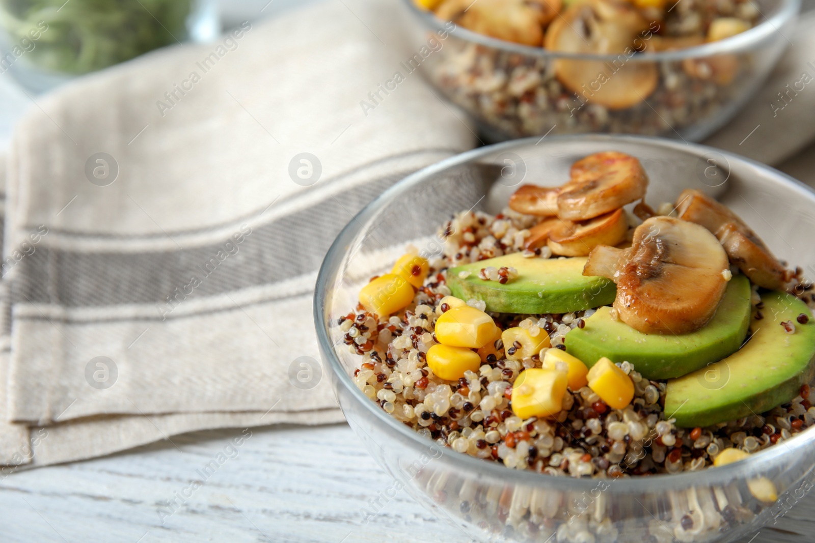 Photo of Healthy quinoa salad with vegetables in bowl on wooden table, closeup. Space for text