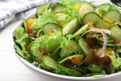 Bowl of delicious cucumber salad on white wooden table, closeup