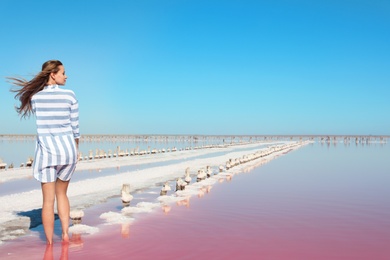 Photo of Beautiful woman posing near pink lake on summer day