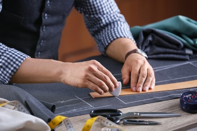 Tailor working at table in atelier, closeup